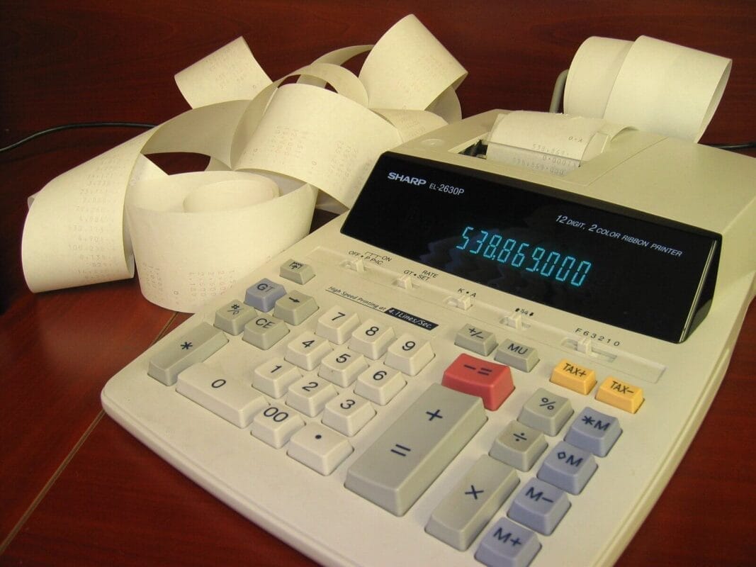 Documentos financeiros, gráficos de desempenho e calculadora sobre uma mesa de escritório, representando o estudo do patrimônio na contabilidade.